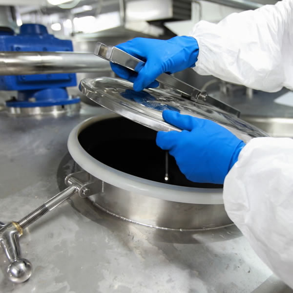 Scientist opening lid of large bioprocess vessel 
